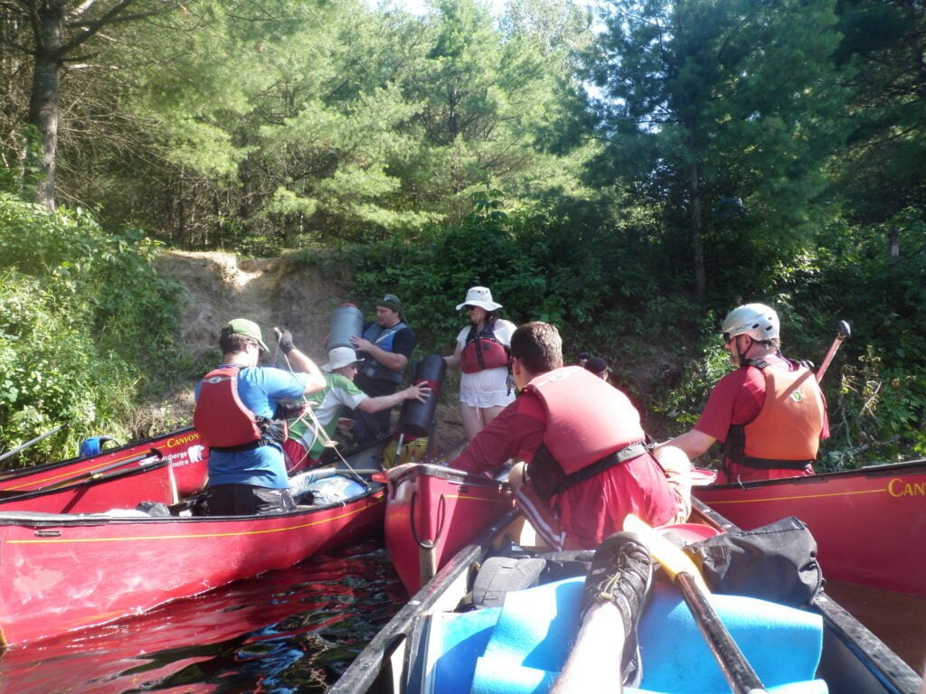 Unloading gear from canoe to campsite on Noire river