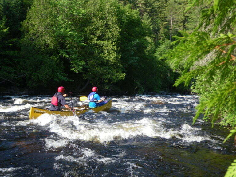 Tandem canoe in middle of whitewater rapids