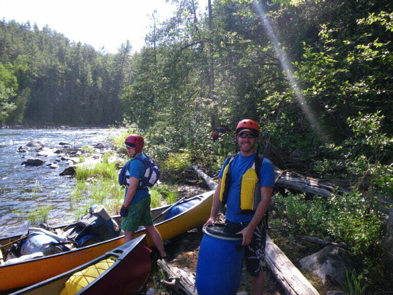 Canoes being loaded with equipment on the shore 