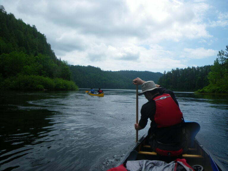 View from stern paddler of front canoe paddler, and picturesque view