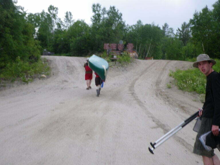 canoe being portaged on dirt road