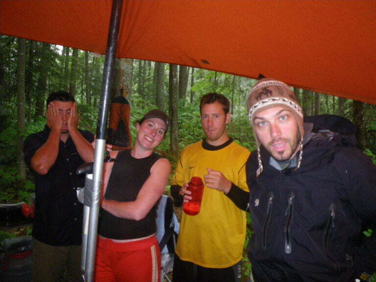 huddling under guide tarp avoiding rain