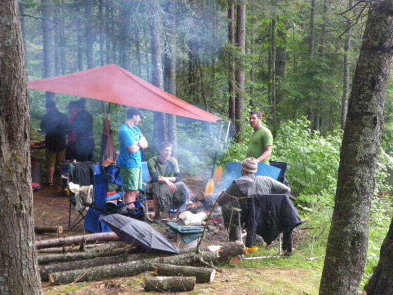 campsite with fire and guide tarp shelter