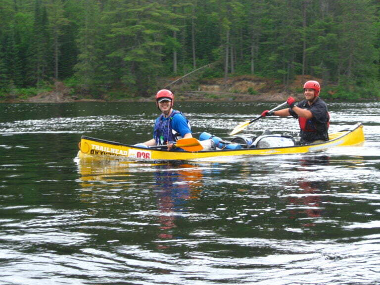 yellow canoe filled with water but still rightside up after rapids