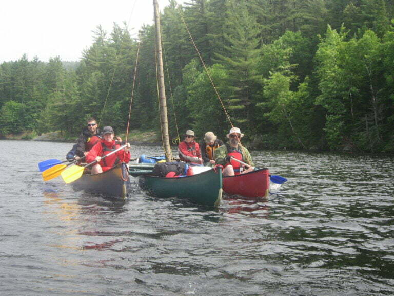 canoe trimaran on the river with paddlers and gear